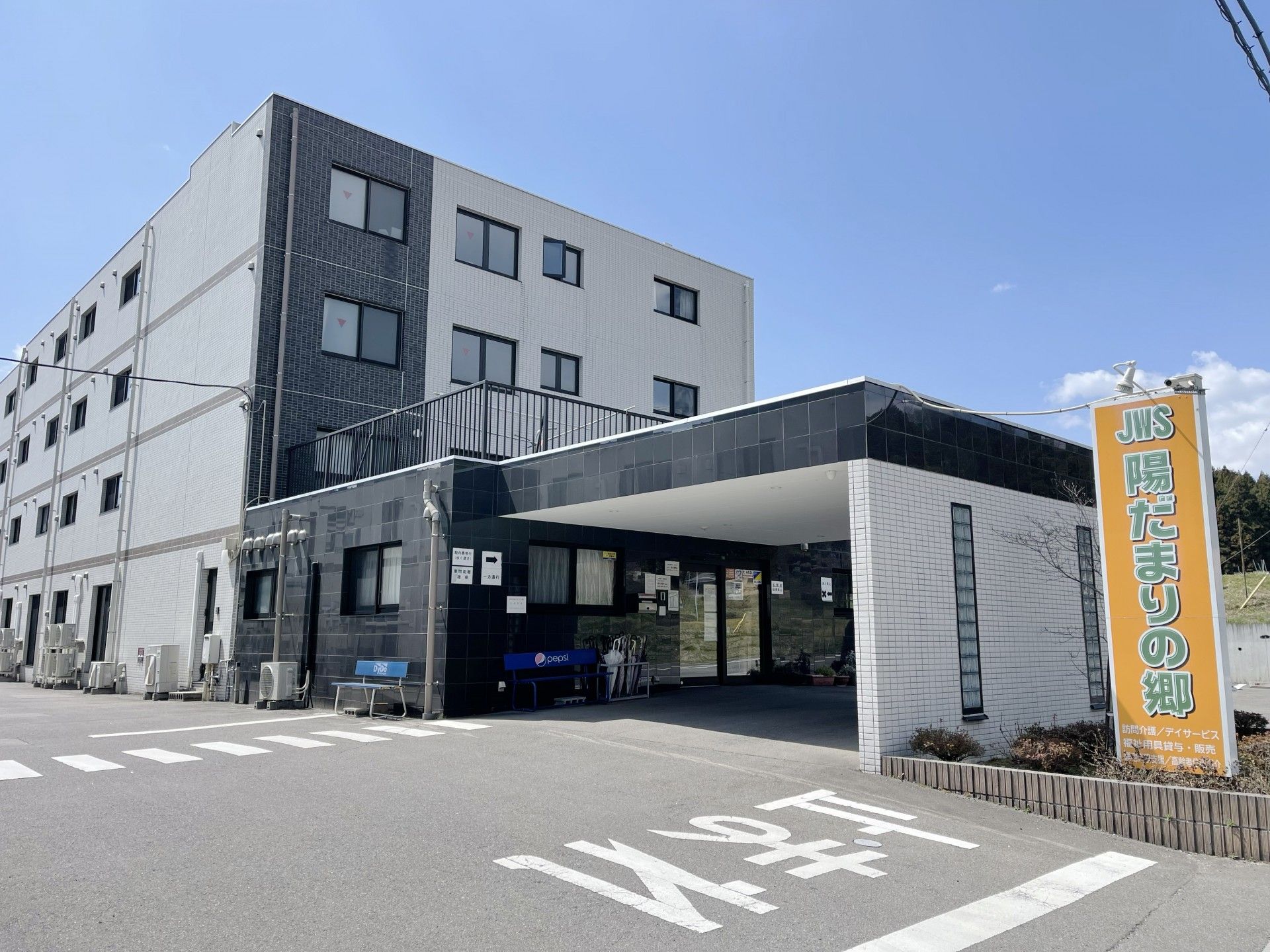 白い部分と茶色い部分に分かれている建物。4階建てになっている