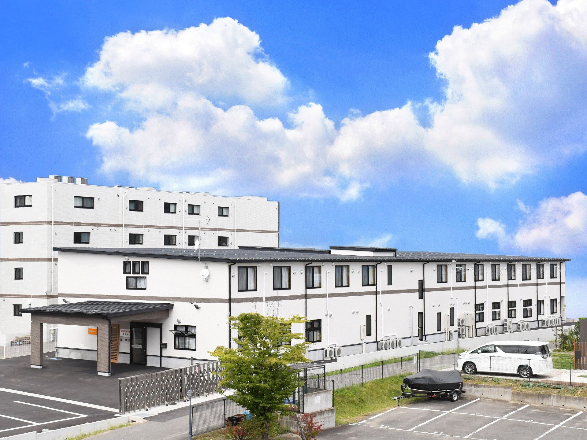 横長の2階建ての建物。奥には4階建ての建物が見える
