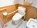 共有トイレには、温水洗浄便座が完備されている。手すりや汚物処理スペースがそばにある。カーテンで仕切られている。