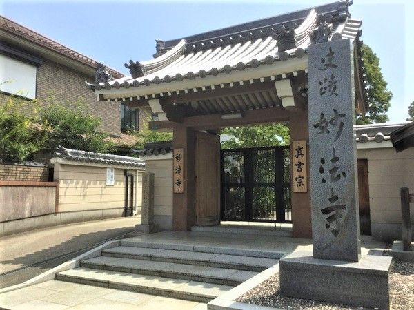 「妙法寺」と書かれた立派な門構え。階段を上るとゲートがあり、境内へと続いている。