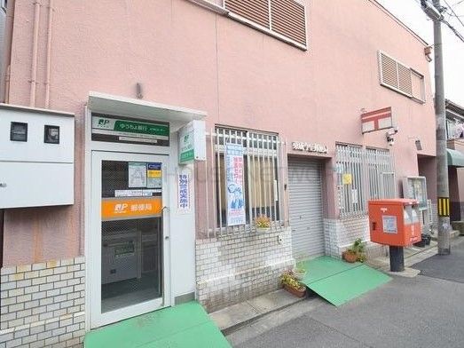 郵便局の前には赤いポストがあり、出入り口にはスロープが設置されている。