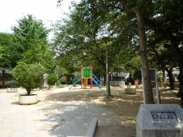 滑り台などの遊具が設置された緑あふれる公園。