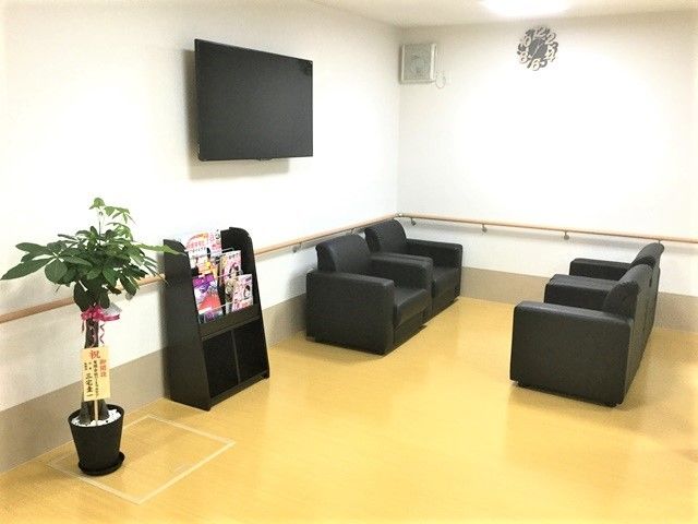 黒い数でまとめられた落ち着いた雰囲気の談話スペースにはソファセットやテレビ、ブックラックがある。