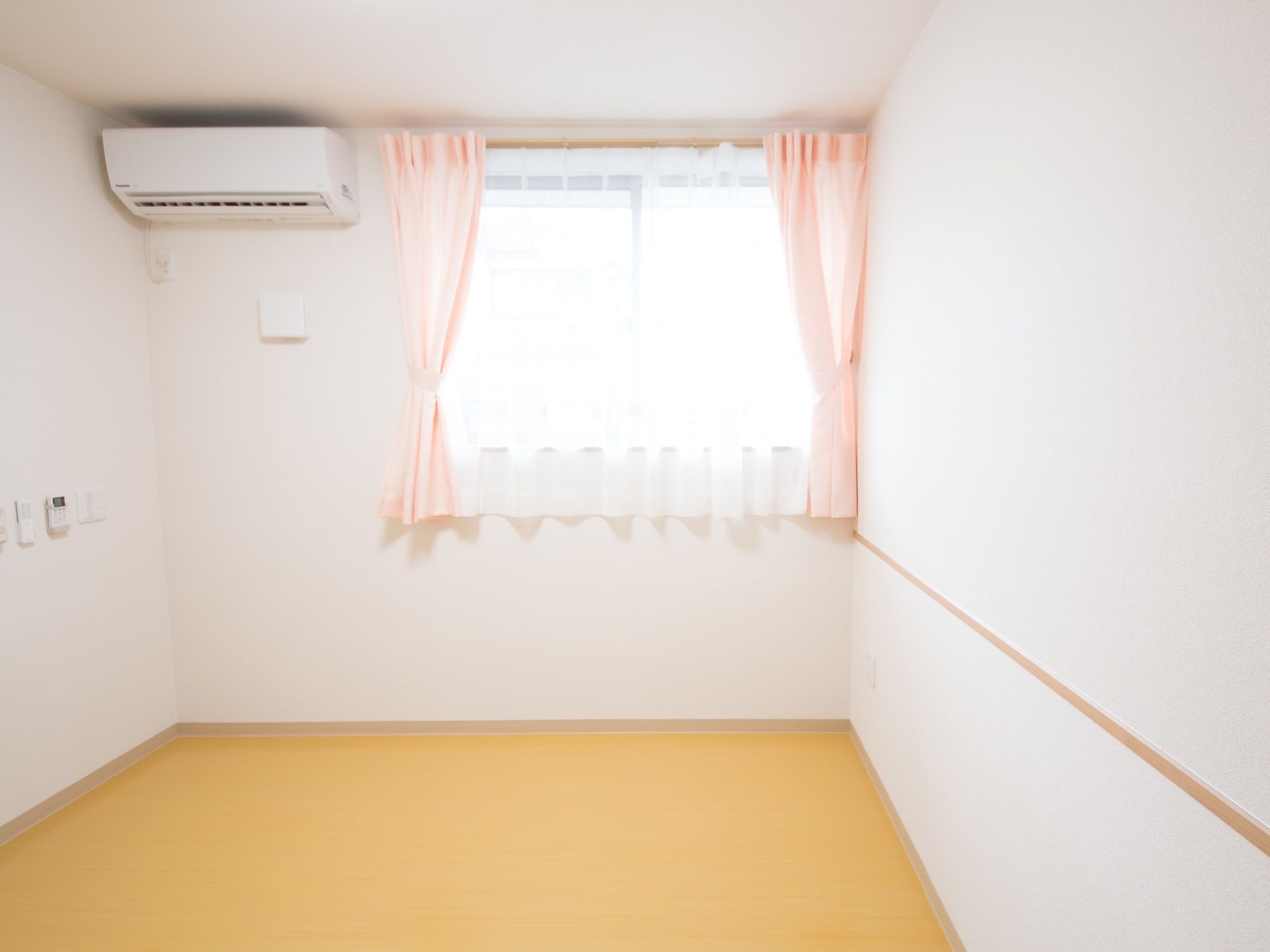 たくさんの日差しが差し込む、大きな窓がある居室である。また、エアコンが設置されており、室内を快適な温度に保つことができる。