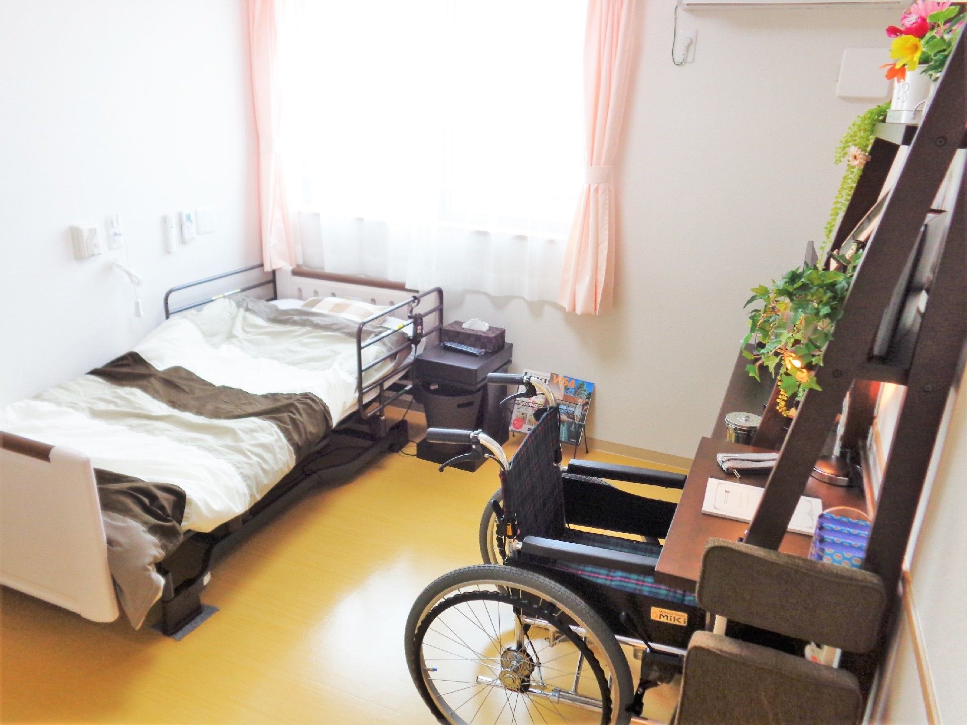 ベッドやデスク、車いすなどがある居室には季節の花も飾られている。