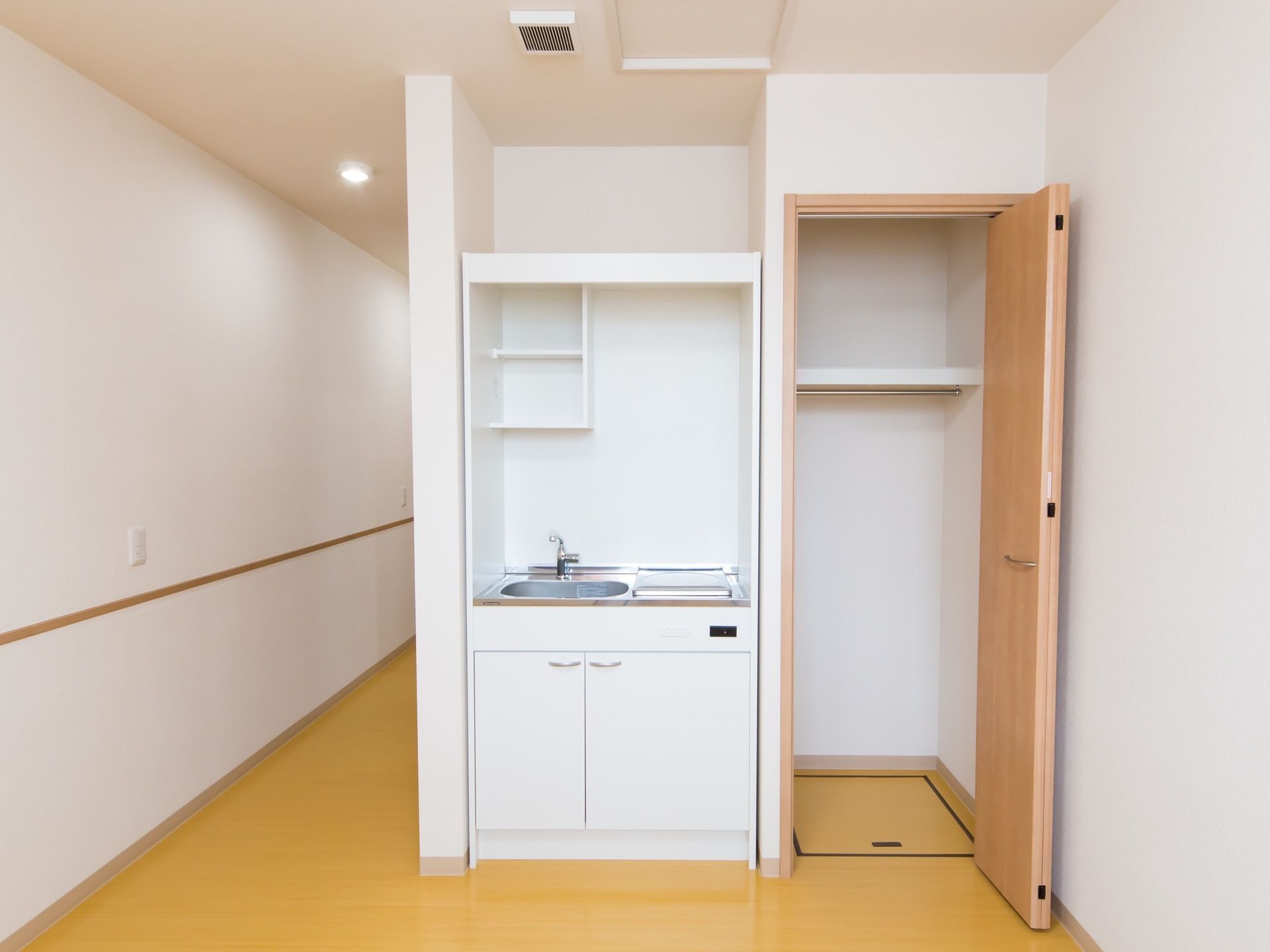 居室にはシンプルなミニキッチンが備わっている。下の段に戸棚があるほか、流し台の真上に小物を置くスペースがある。