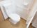 居室のトイレはカーテンで仕切られたスペースに設置されている。壁には手すりがあり、体を支えながら安全に利用することができる。