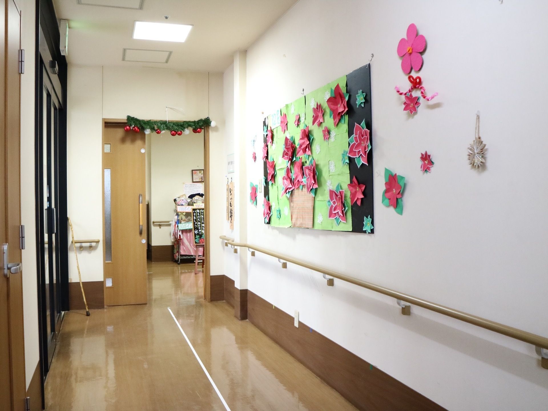 廊下の真っ白な壁に手作りの作品が飾られている。扉はスライド式になっており、大きな取っ手が付けられている
