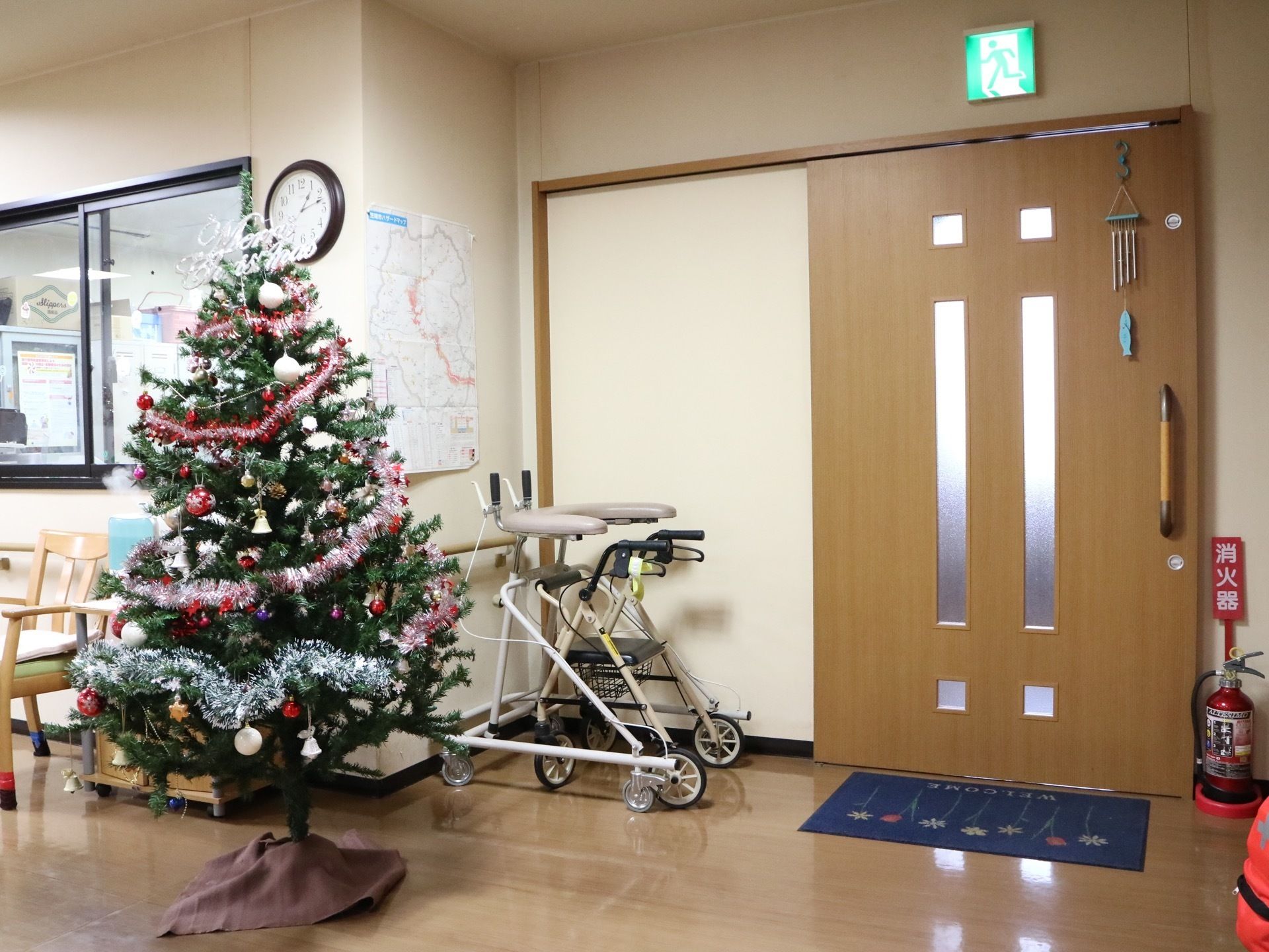 大きなスライド式の扉が設置されており、上には非常口のマークがある。扉の脇には消火器が置かれており、緊急時への備えがされている。