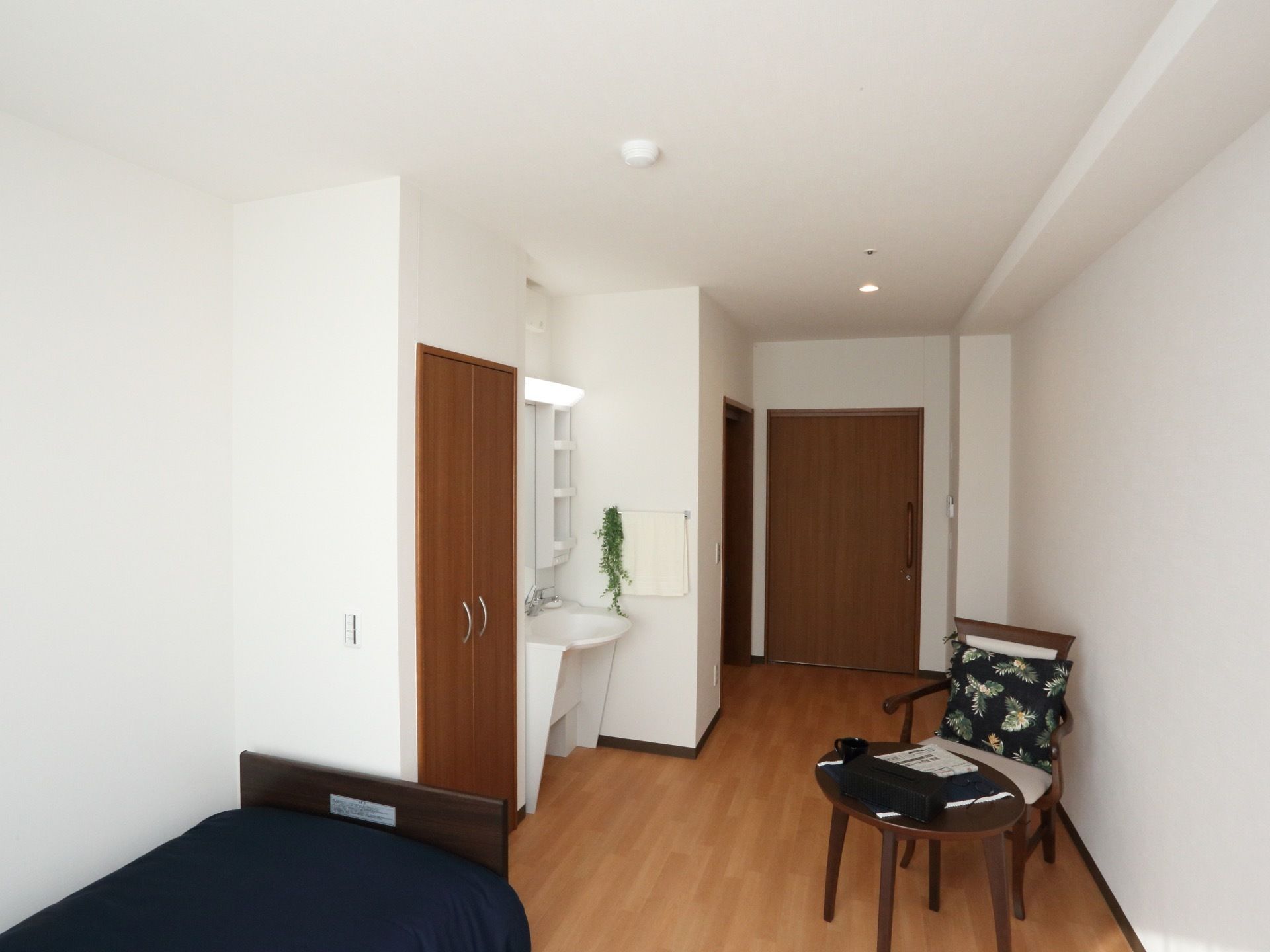 入口扉は引き戸になっており、入口右手にトイレがある。その横に洗面台があり、壁にタオル掛けが取りつけられている。