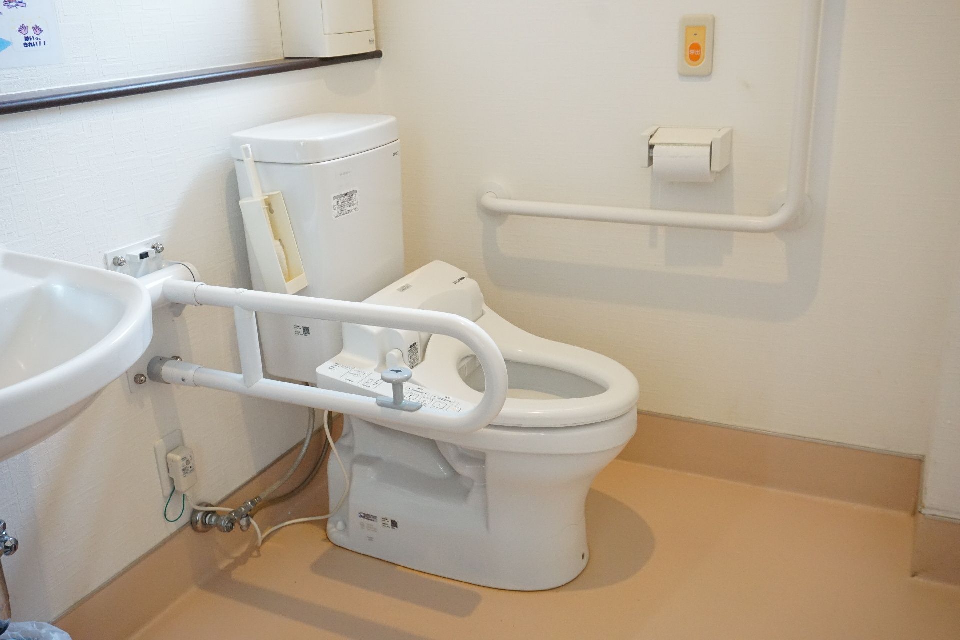 バリアフリー完備で、大きな手すりが壁に取り付けられているトイレ