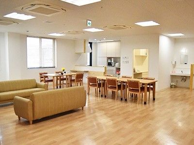 対面式のキッチンが付いた共有スペースにはダイニングテーブルやソファが置かれている。