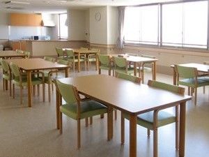 ４人掛けのダイニングテーブルが複数並び、車いすの入居者も使えるよういすが置かれていないスペースもある。