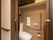 居室内のトイレの内部である。引き戸の入口になっており、中央に温水洗浄便座が設置された洋式トイレがある。