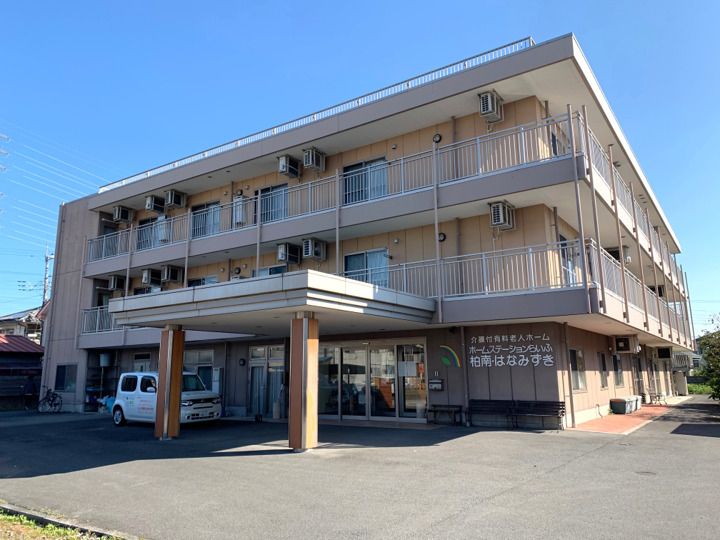 3階建ての建物。2階と3階にはベランダがあり、1階には車寄せがある。