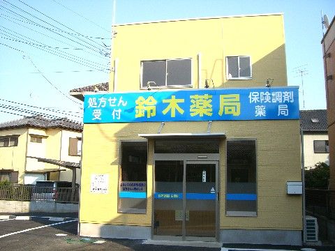 正面に名前が標記された、黄色い外装の薬局。近くには駐車スペースもあるので、車で薬を取りに行くことができる。