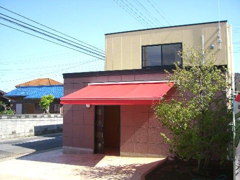 赤い日よけのテントがある、街になじむ色合いの２階建ての施設である。玄関前はバリアフリーで、自動ドアとなっている。