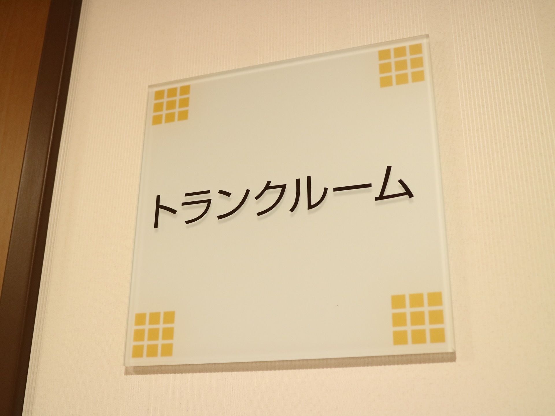 トランクルームと書かれたプレートが壁に取り付けられている。シンプルなデザインと大きなカタカナ文字で読みやすい。
