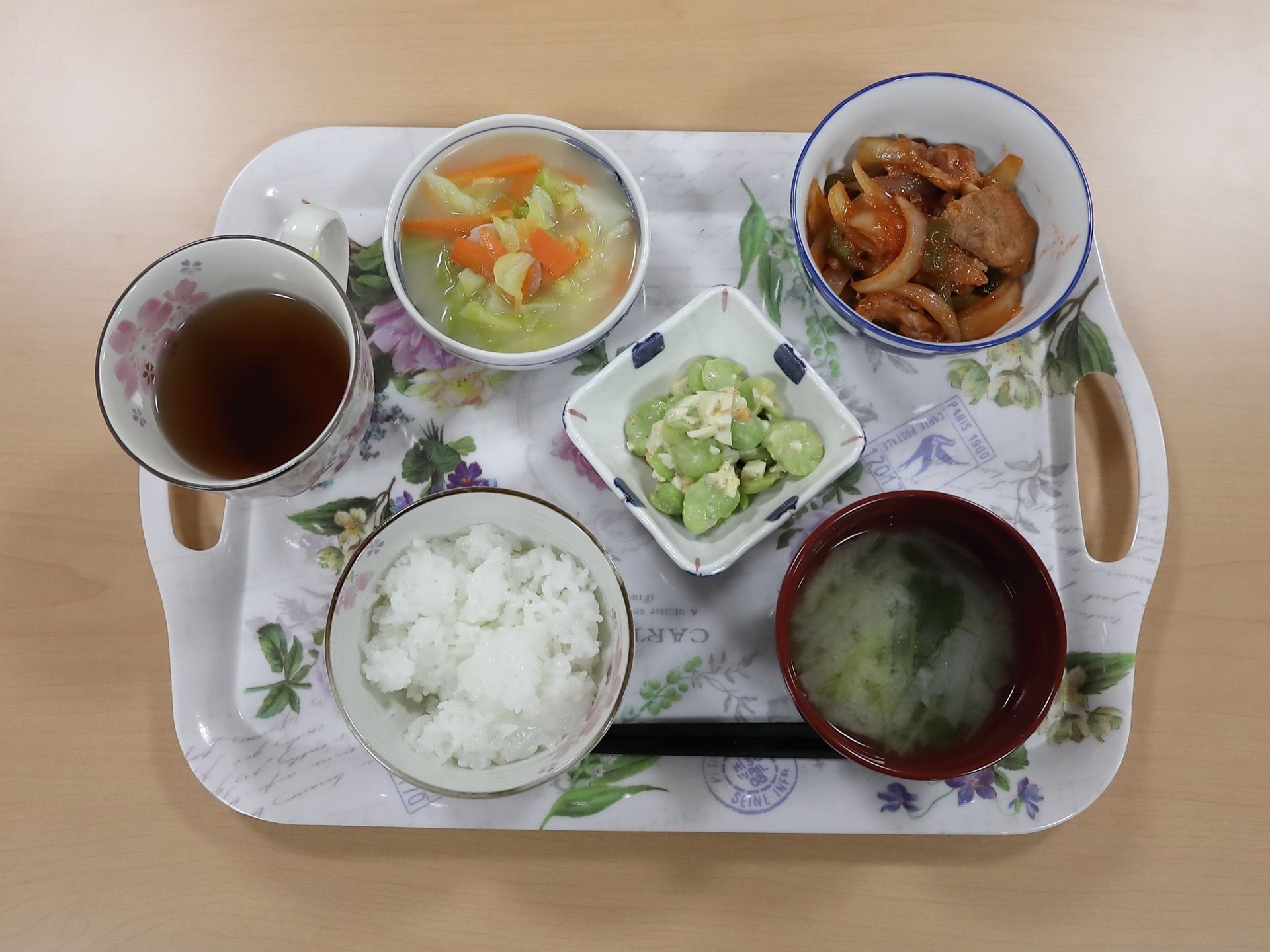 テーブルの上に置かれた、両サイドに持ち手のついた花柄のトレーに、料理を盛った器がきれいに並べられている。