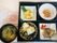 栗ご飯のおにぎりや魚の煮つけ、揚げ物や野菜の和え物がお弁当風に盛られ、みそ汁が添えられている。