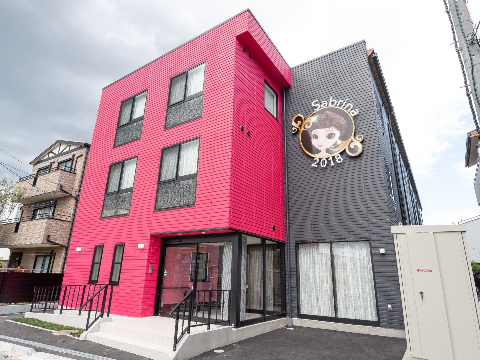 ピンクと黒の目立つ建物は3階建て。外壁に描かれたサブリナのキャラクターがほほ笑んでいる。