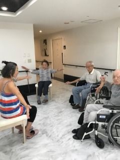 ボーダーのラフな服装をしたスタッフが体操の指導をしている様子。