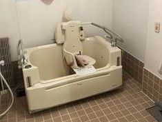 白い機械浴槽。座ったまま入浴できるタイプ。