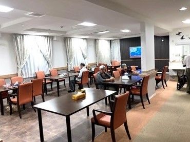 レストランのような雰囲気の食堂にはセンスのいいダイニングテーブルが複数並んでいる。