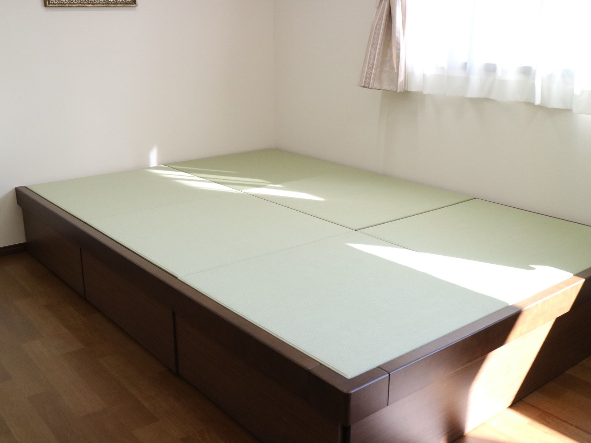 陽射しの入る窓が設置された白い壁際のコーナーには、小上がりに3畳ほどの畳敷きスペースが設けられている。