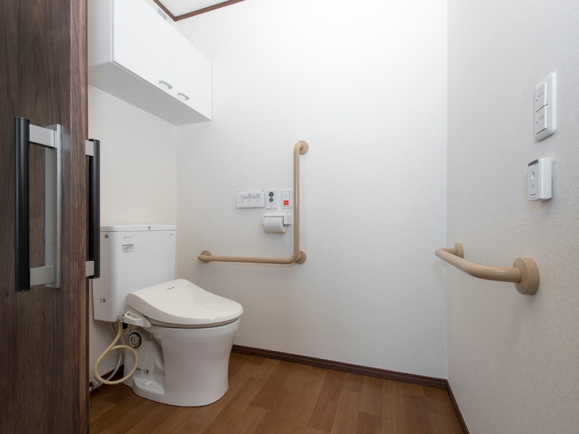 シンプルなトイレには手すりが付き、車いす対応の広さを確保。呼び出しボタンもある。