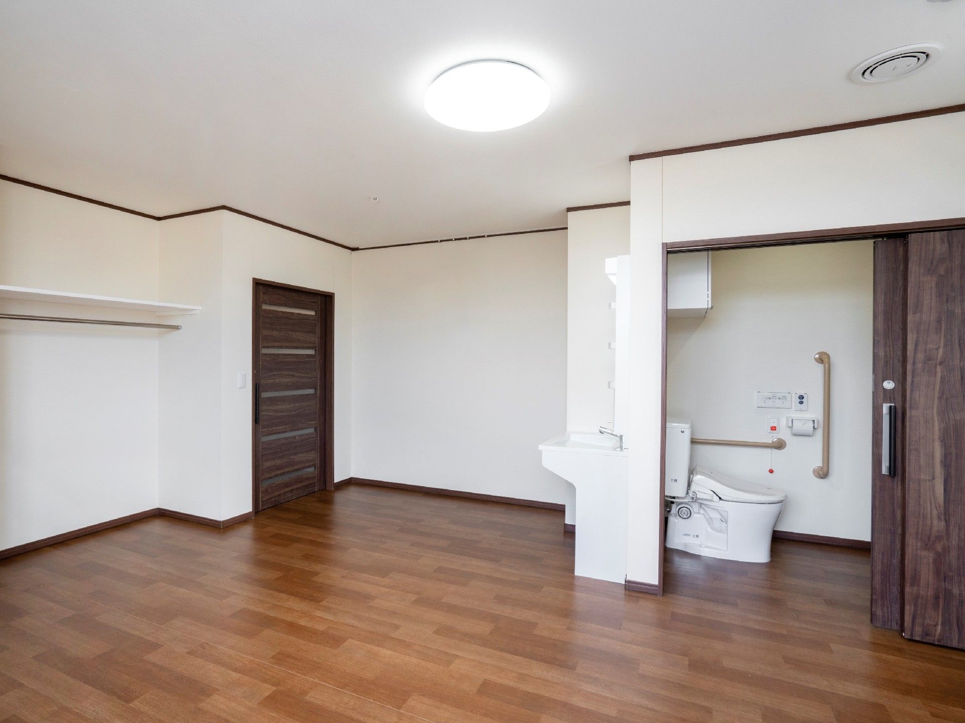 トイレや洗面所が付いたシンプルな居室はフローリングで介護対応型のデザイン。