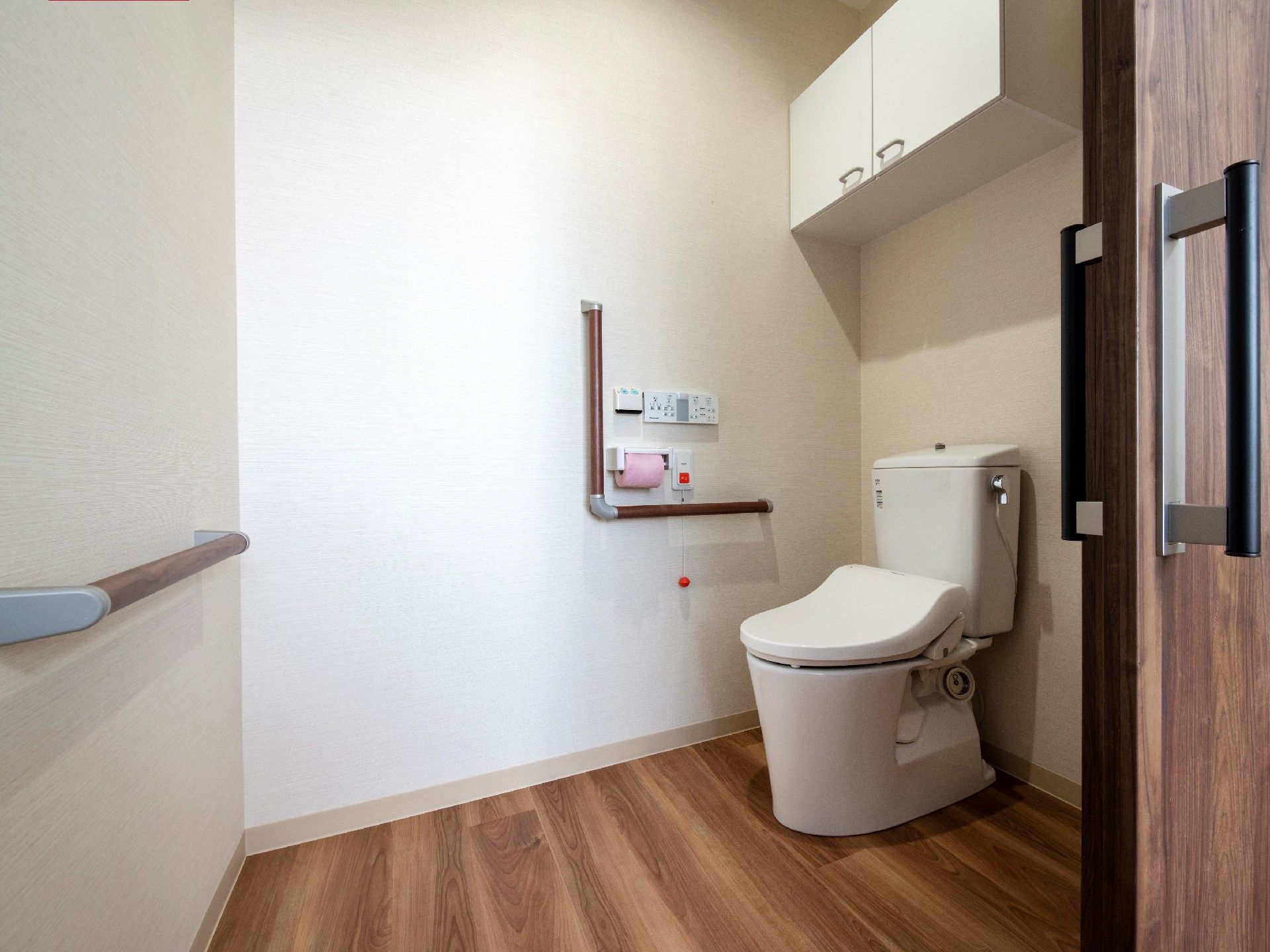 トイレにはエル字型の手すりや呼び出しボタン、収納を完備。出入り口には引き戸が付いている。