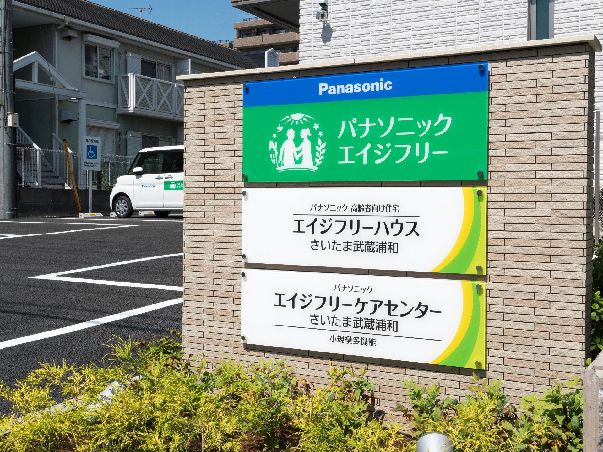 大きなプレートが貼られた門。住宅や併設事業所の名前が書かれている。