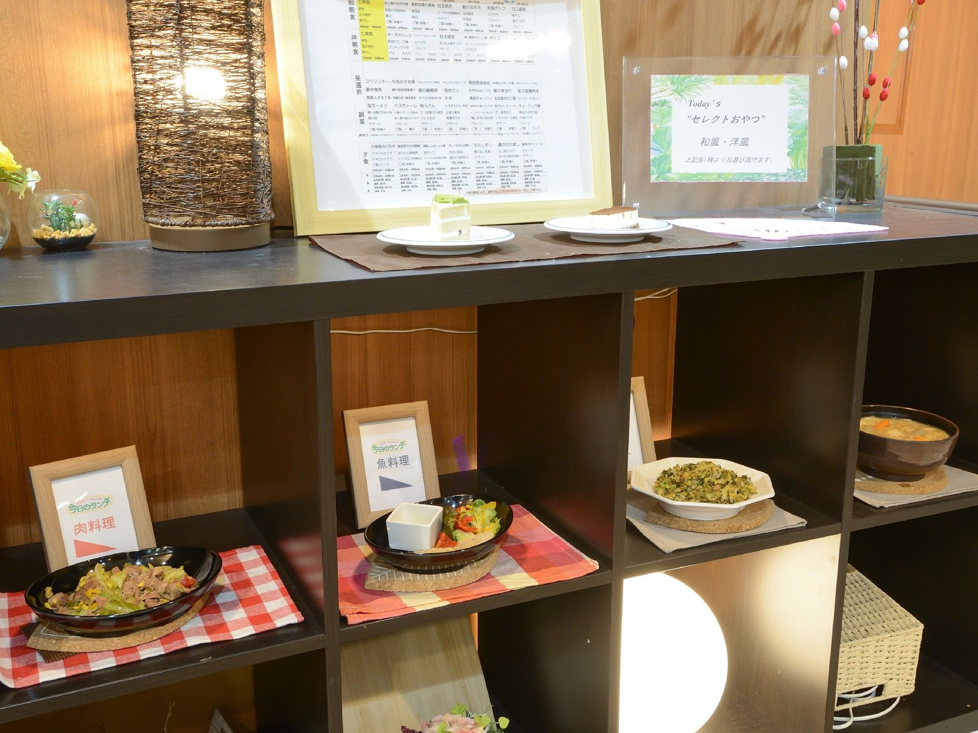 天ぷらや焼き魚、汁物が添えられたイベント食。花や桜のモチーフで季節感を演出している。