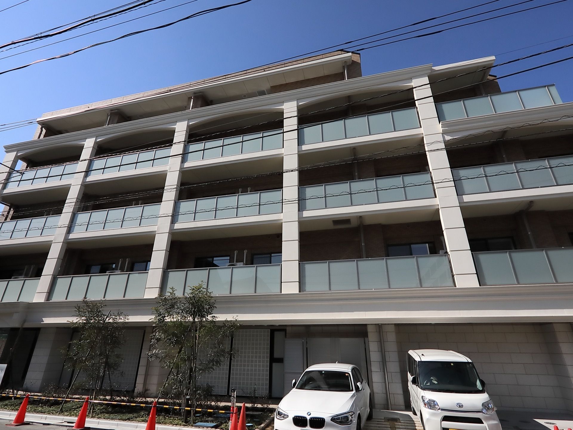 外壁がグレー色の５階建ての建物である。ベランダを設置しており、外の風を感じながらリフレッシュすることができる。