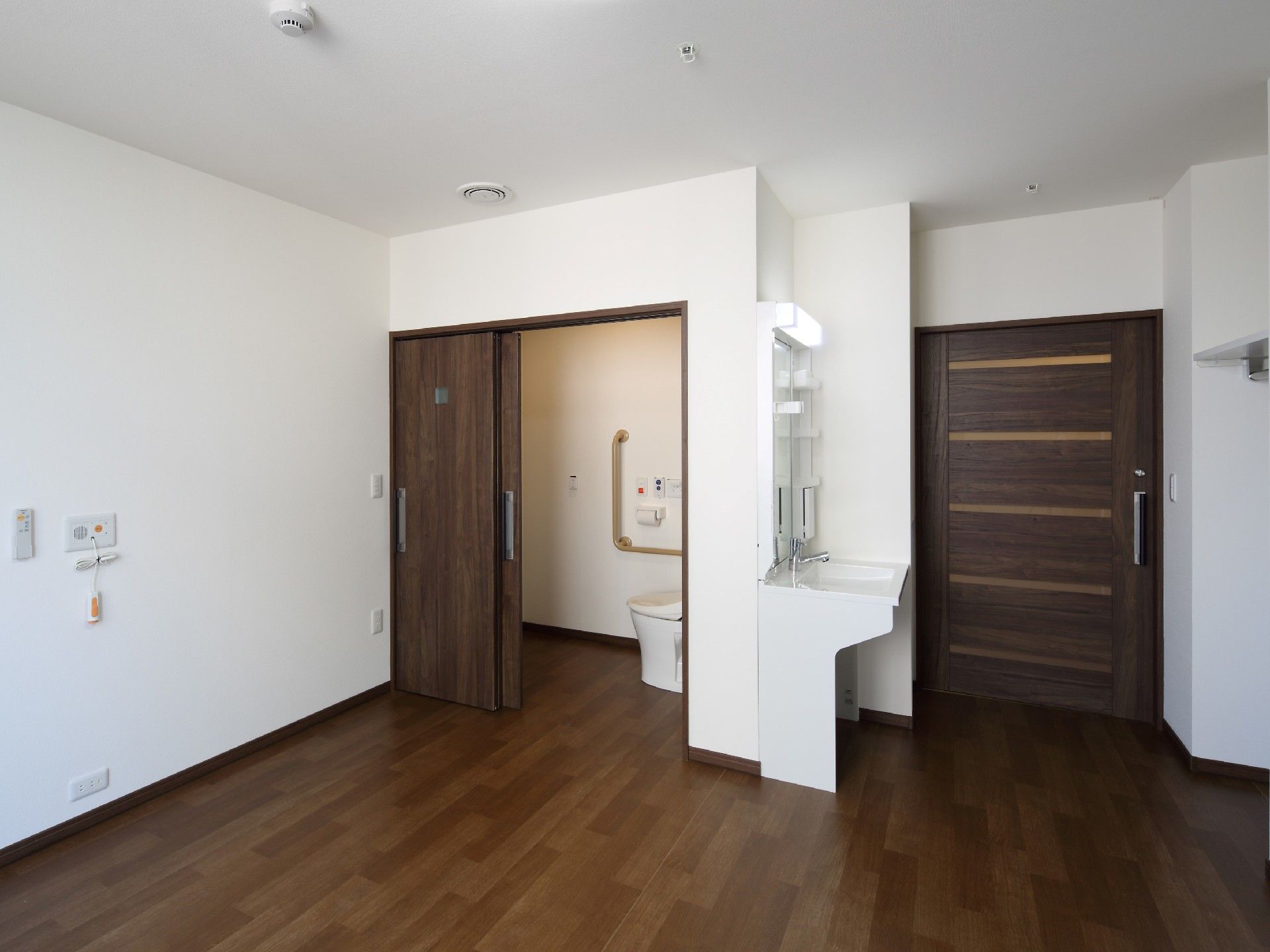 引き戸が付いたトイレは広く、洗面所や緊急通報装置も居室についている。
