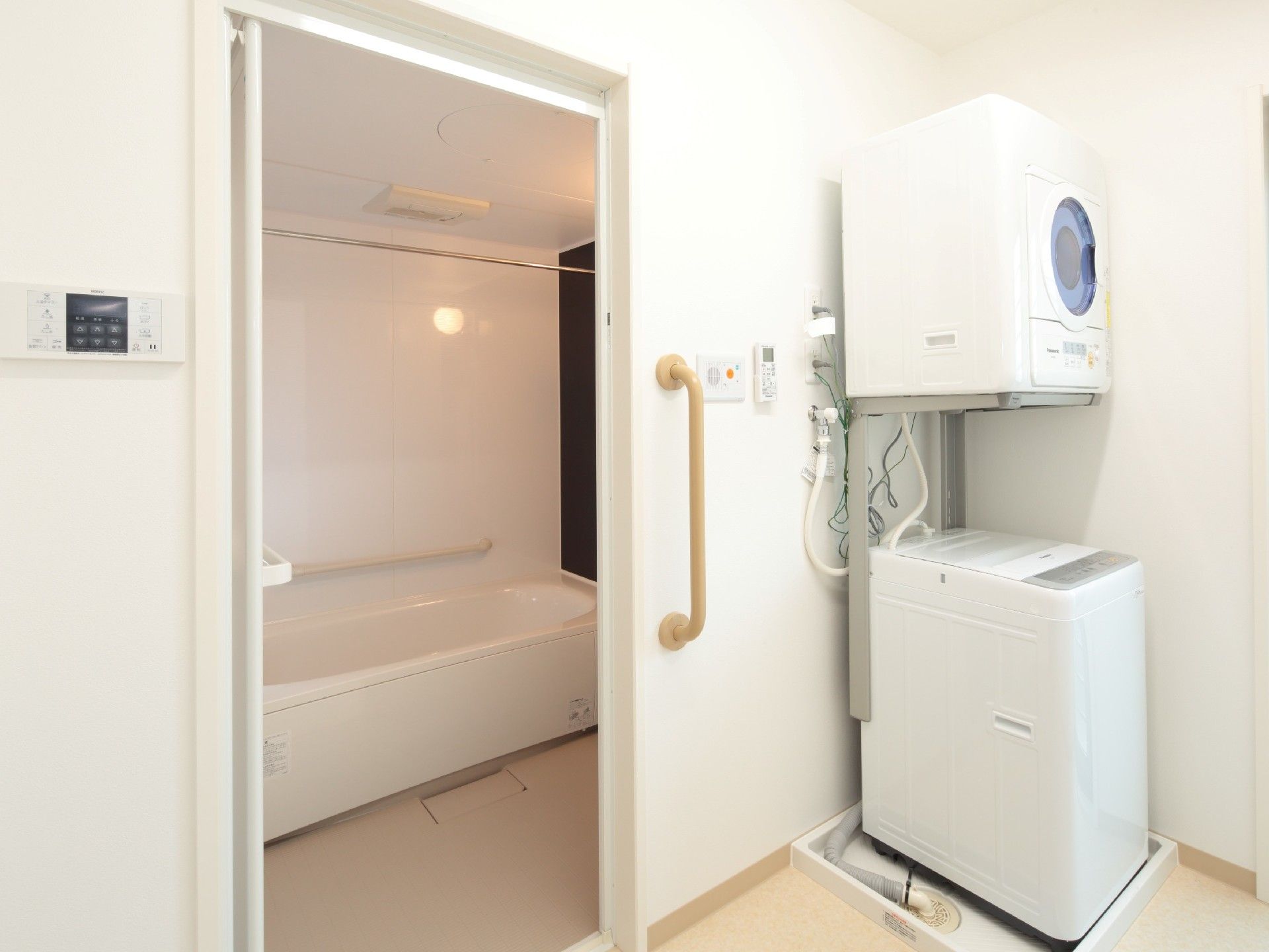 洗濯機と乾燥機が置かれた脱衣所と一人用の浴槽が設置された浴室は白をメインとしている。