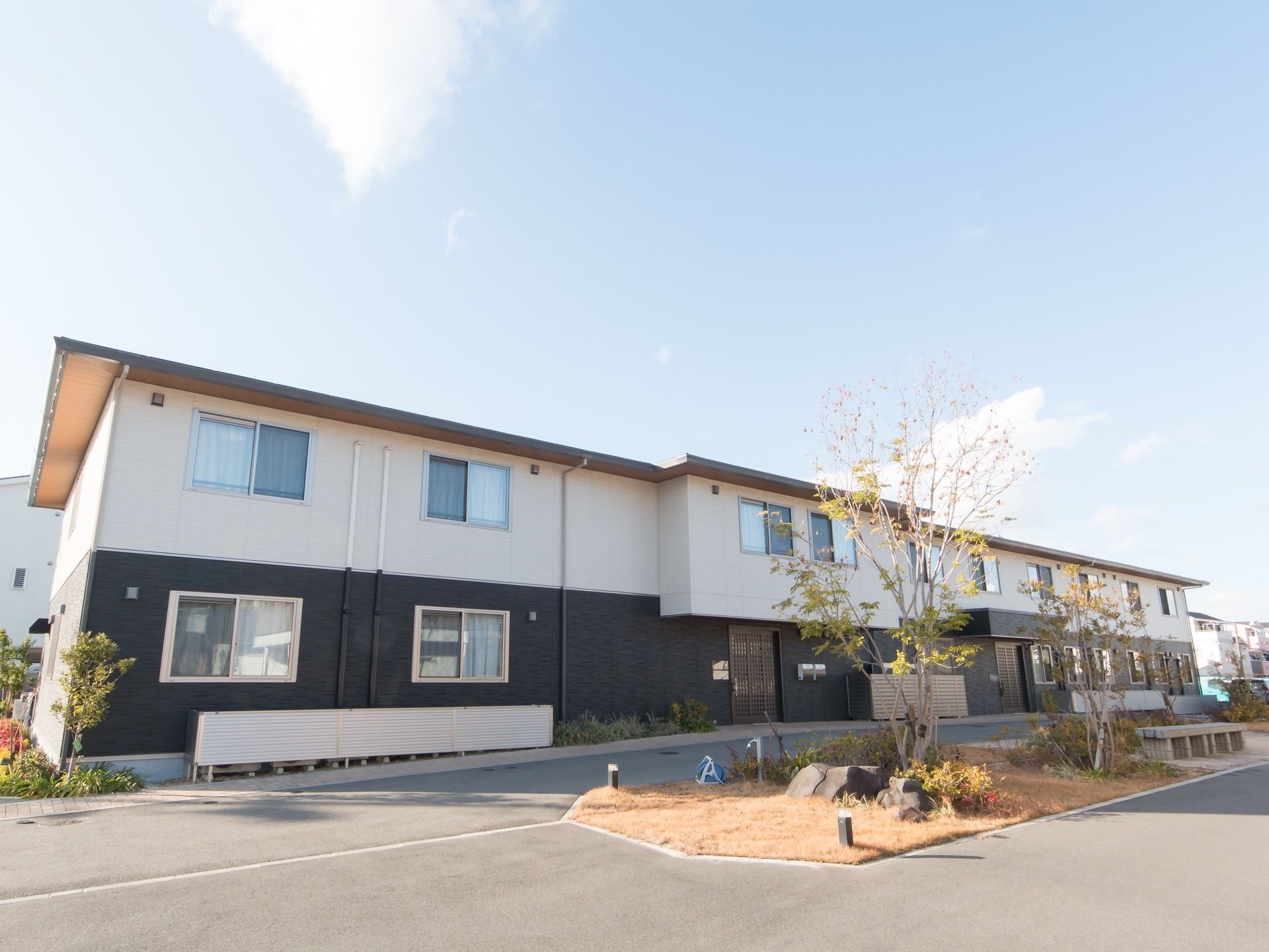 １階部分が濃い茶色、２階部分が白色のツートンカラーの外壁を持つ２階建ての施設である。敷地内にベンチが置かれた植栽がある。