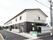 ２階建ての建物。グレーを基調とし、出入り口には屋根が付いている。駐輪場も完備。