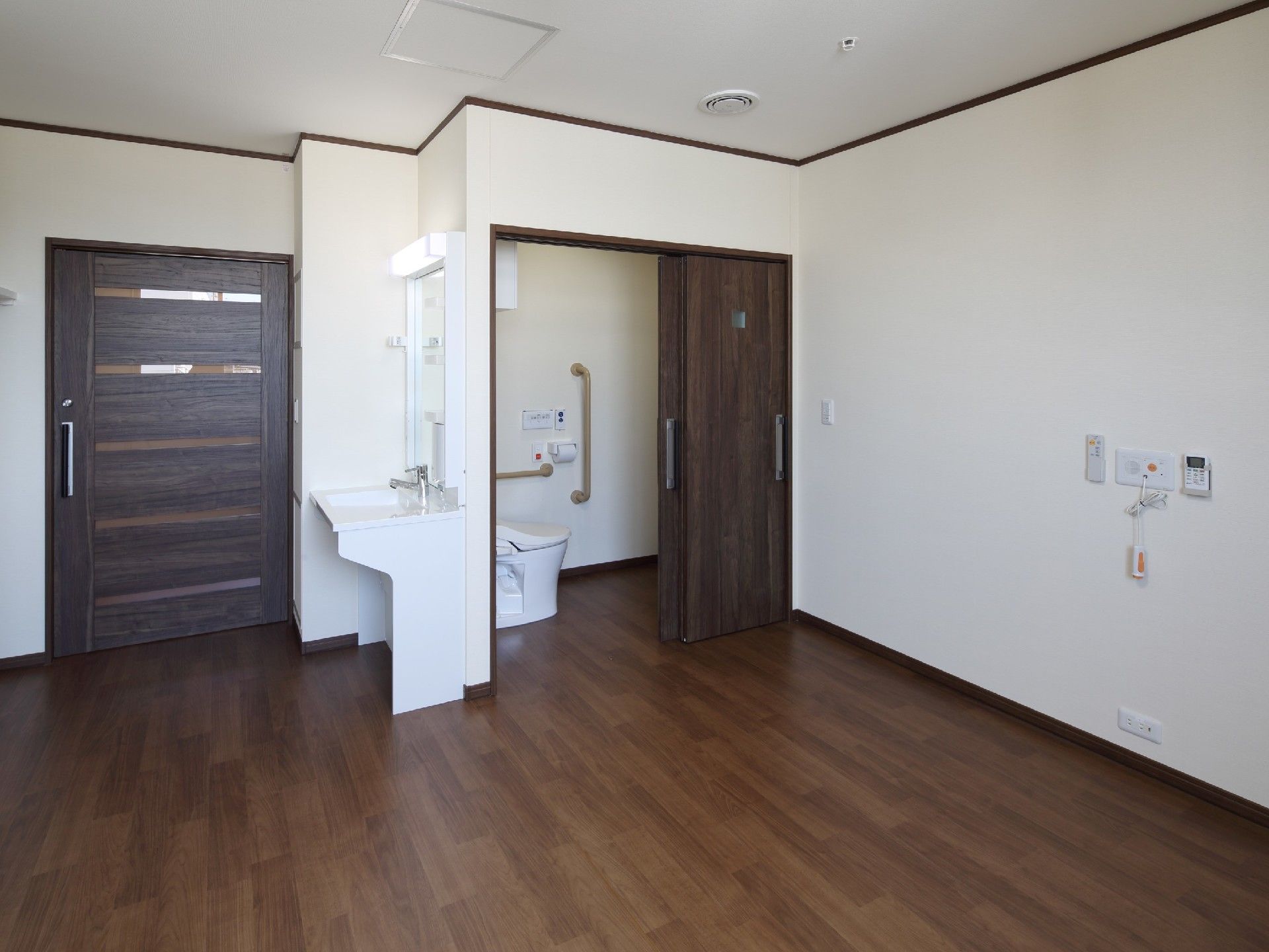 洗面所やトイレがついたフローリングの居室には幅の広い引き戸も設置されている。