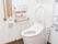 トイレは清潔感のある白い壁で囲まれ、明るく居心地の良い雰囲気。壁には手すりや呼び出しボタンなどの安全対策が施されている。