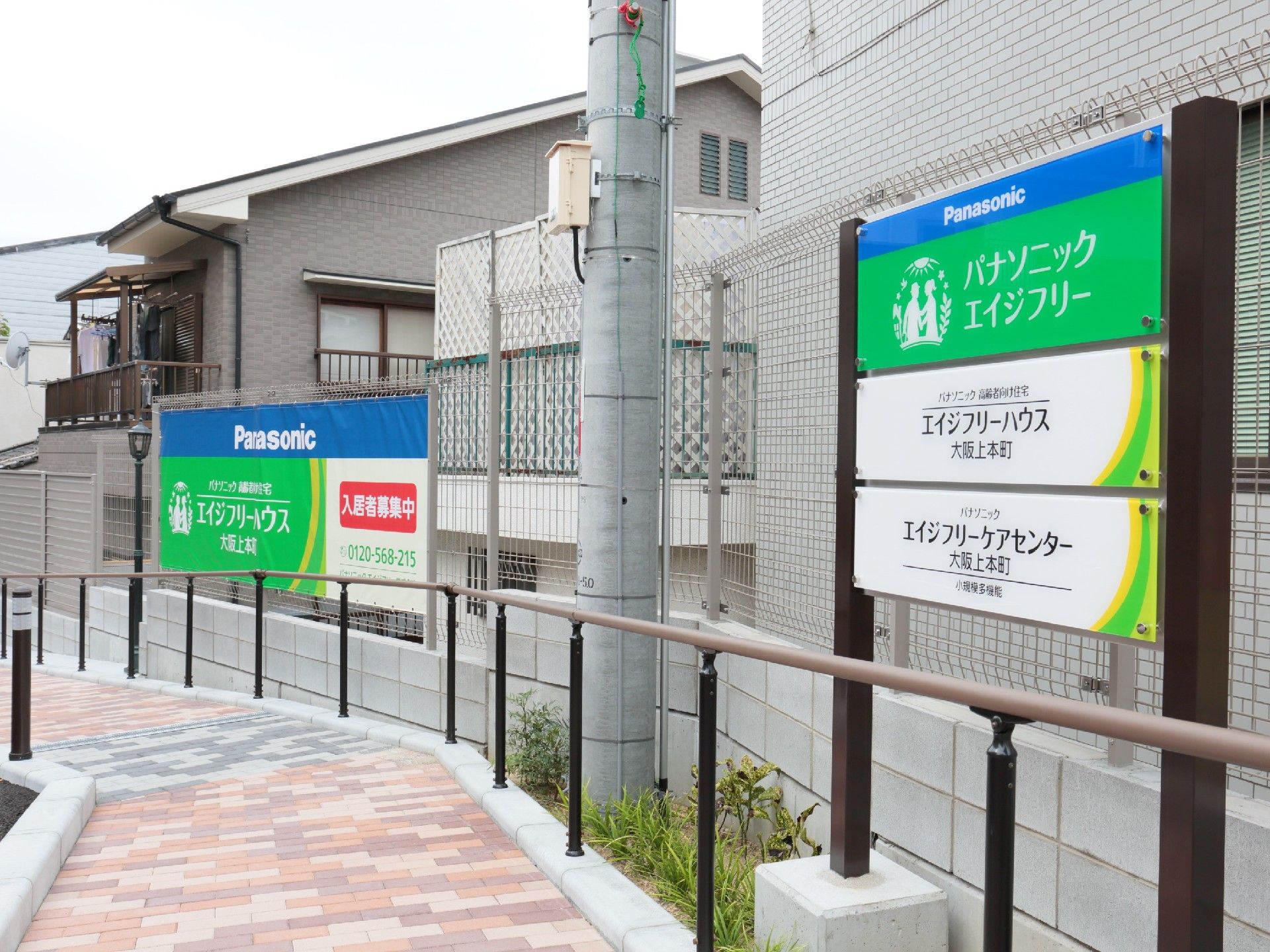 建物の近くの遊歩道からは施設と併設事業所の看板を見ることができる。