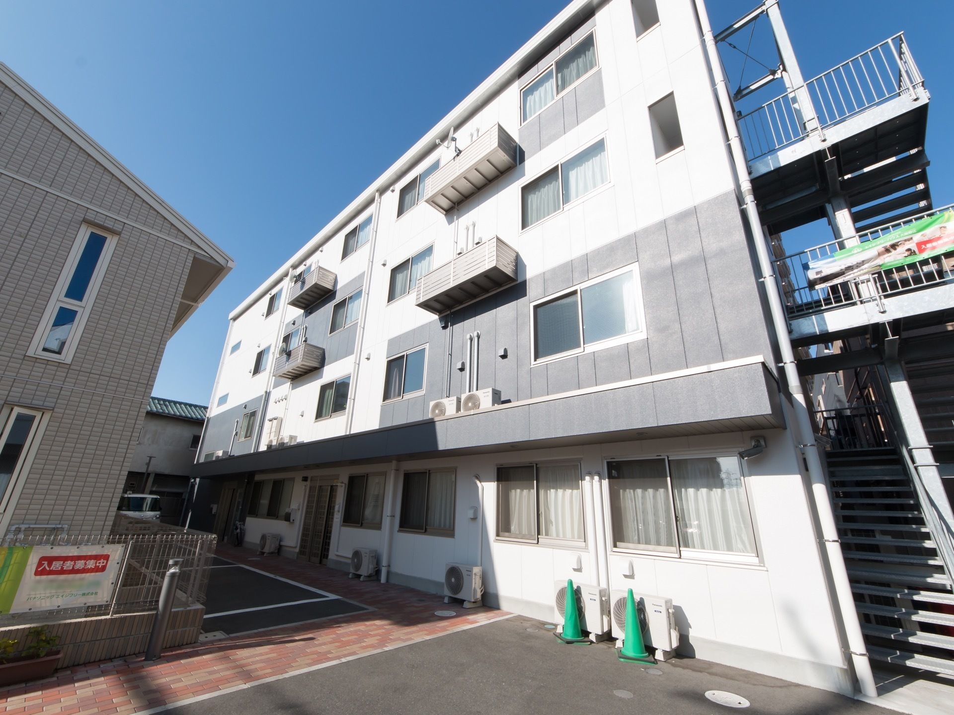 施設は４階建てで、白色と紺色の２色が使われている。外階段があり、緊急時に直接上階から避難することができる。