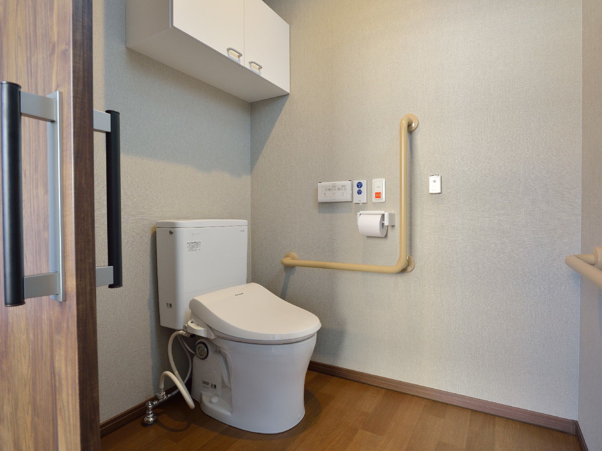 呼び出しボタンがついたトイレにはエル字型の手すりもあり、収納スペースも大きい。