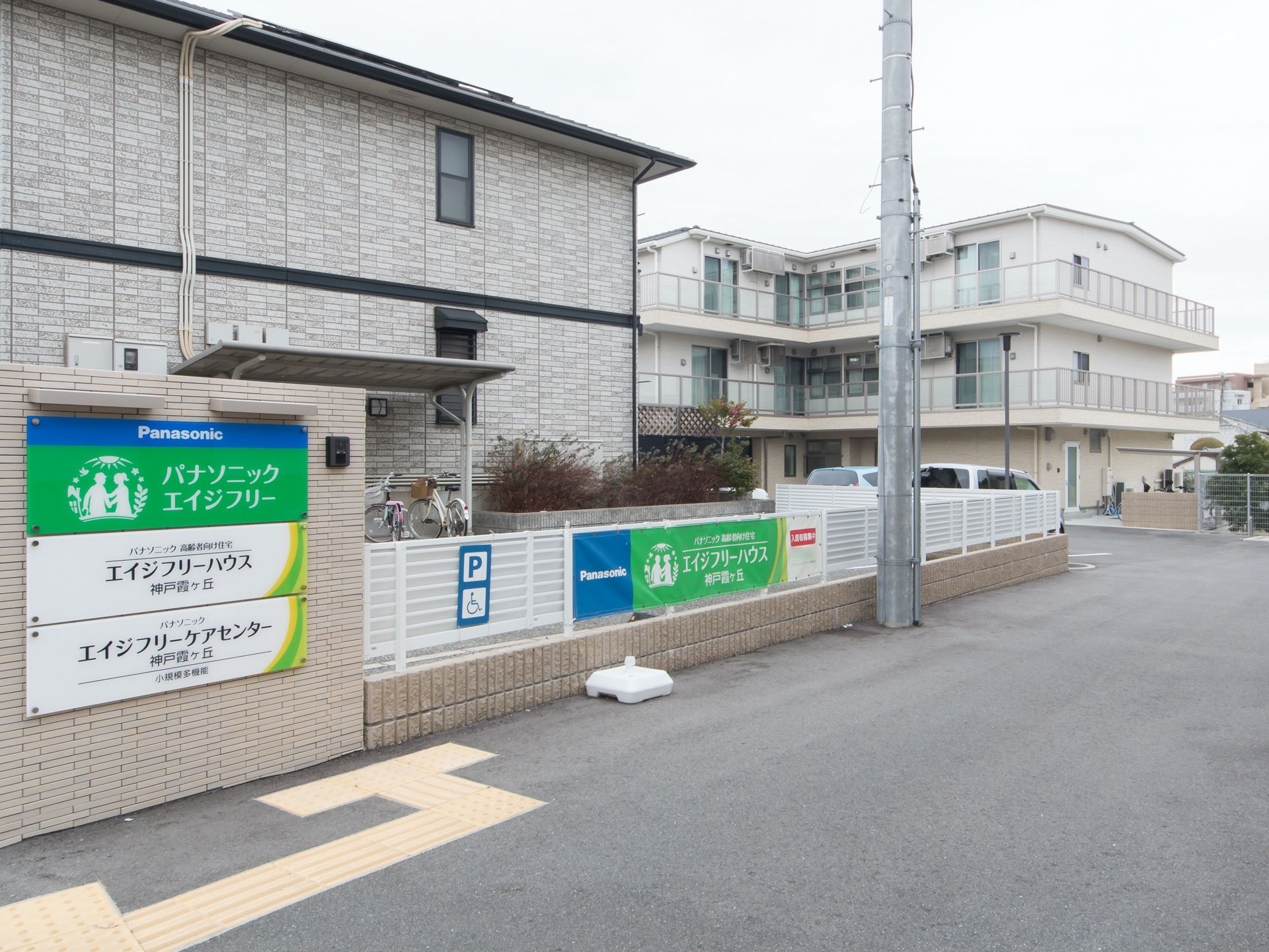施設は道路に面しており、低い塀に囲まれている。敷地内に駐車場が併設され、車椅子マークの付いたスペースも用意されている。