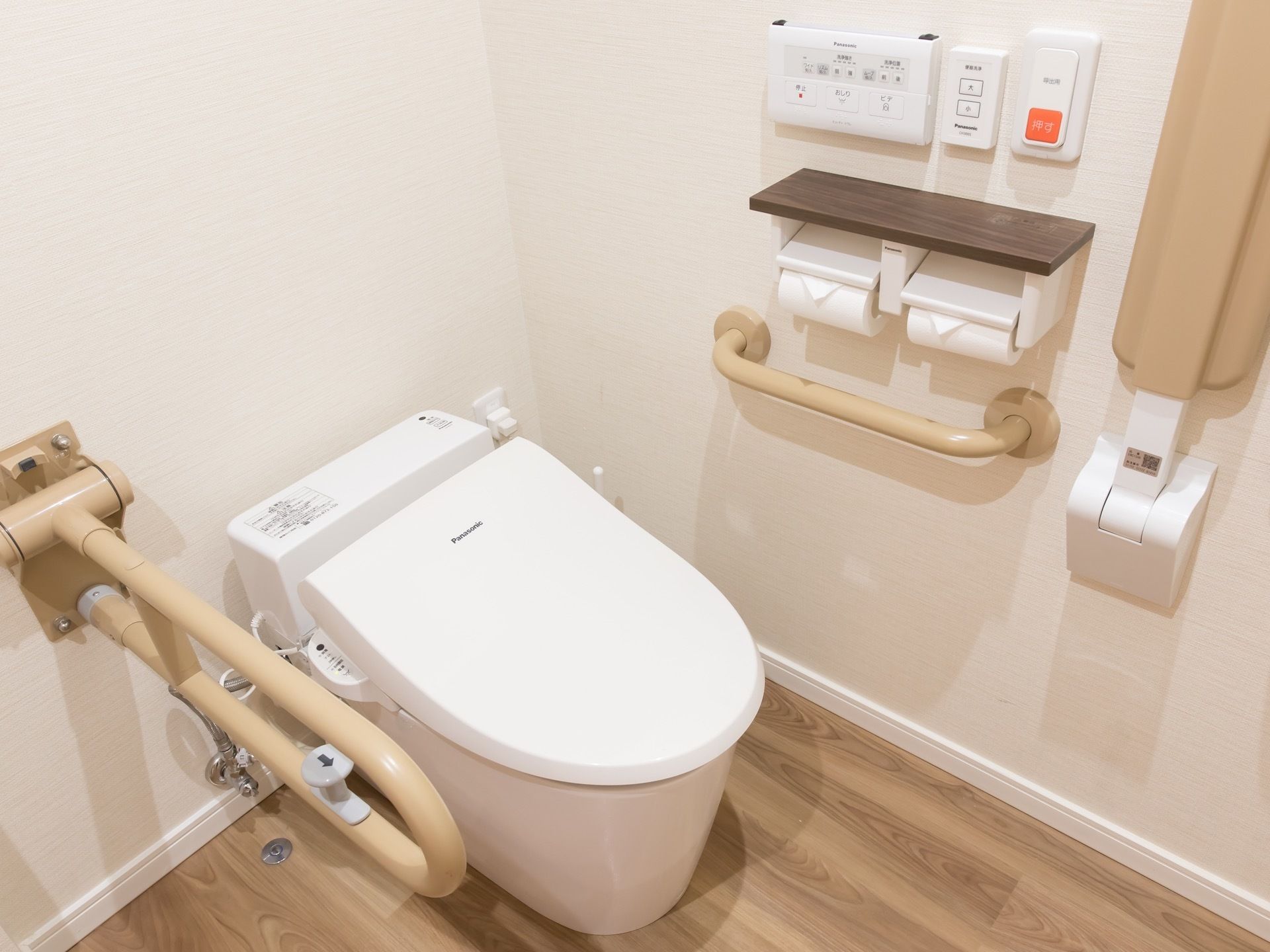 トイレの両側には手すりがあり、折りたたむことができる。操作ボタンや緊急コールが一箇所にまとめられて使い勝手が良い。