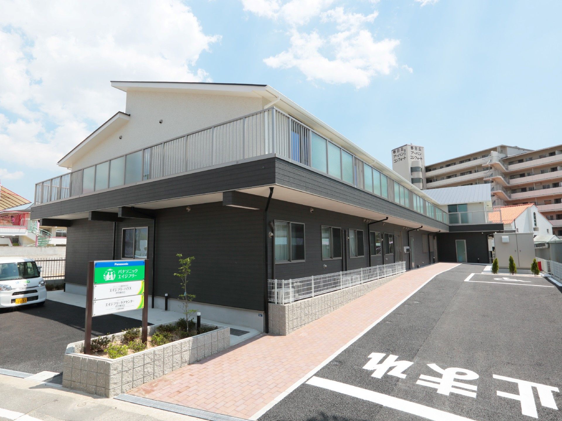 2階建ての建物の側面から見た様子。玄関にはスロープが付き、2階にはベランダもある。