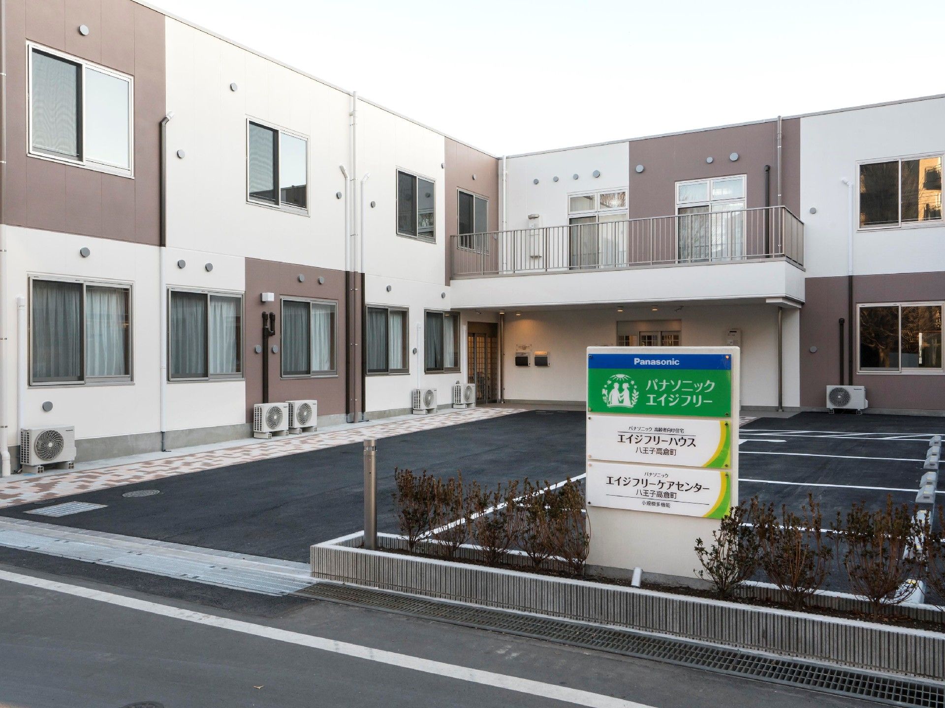 広い駐車場があり、大きな車寄せが付いた建物の前には青、緑などが使われた看板も立っている。