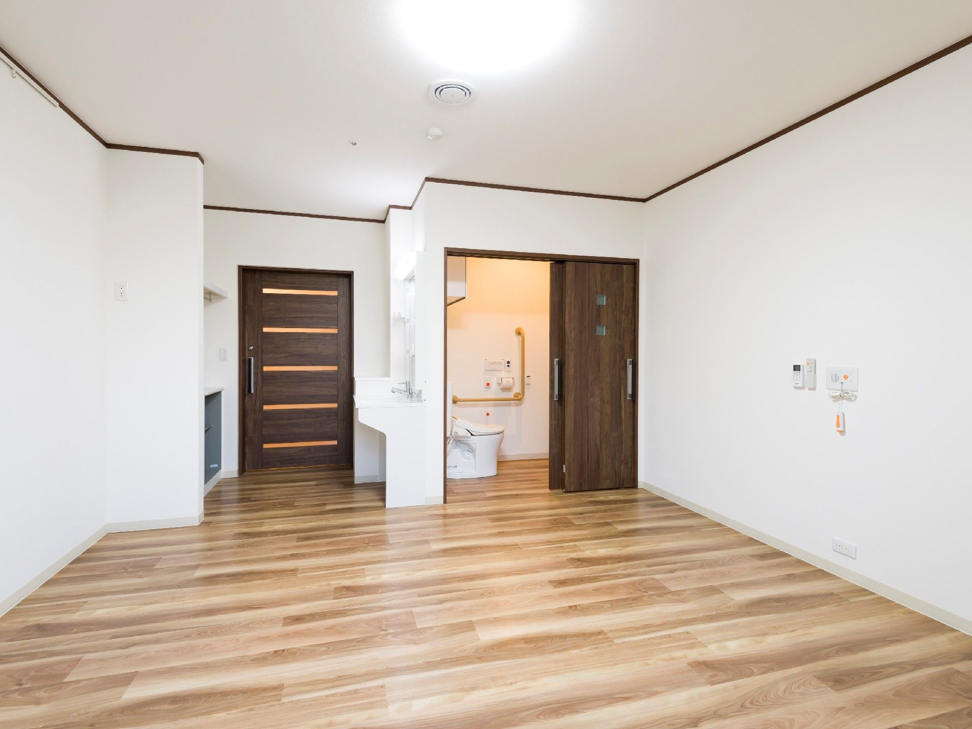 シンプルなカーペット敷きの居室には洗面所とトイレが付き、家具などは置かれていない。