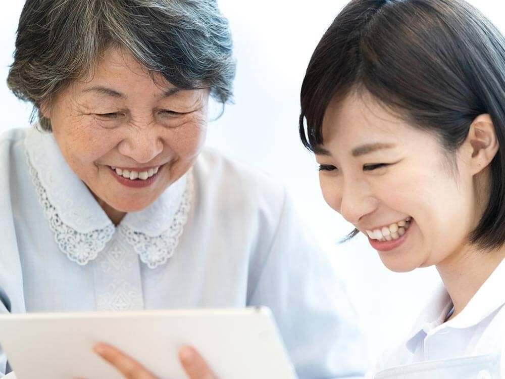 笑顔で話す高齢女性と女性ケアマネジャー